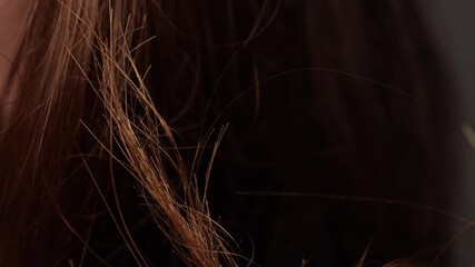 Closeup view of damaged hair strands with visibly split ends showing dryness, breakage and unhealthy hair texture