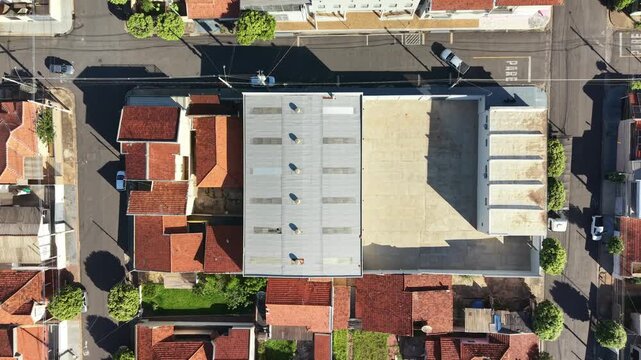 Aerial view showcases a neighborhood with red roofs and street with vehicles