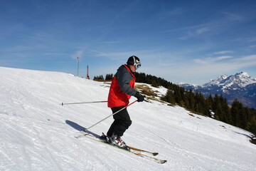 Skier on snowy slope in Morzine Avoriaz, France, surrounded by panoramic snow-capped Alpine mountains. Winter sports, scenic mountain landscape, outdoor recreation.