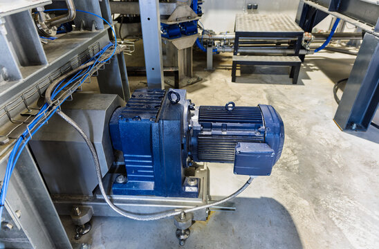 gearmotor unit, which is a combination of an electric motor and a gear reducer, heavy-duty industrial motor and gearbox assembly, part of a larger mixing or shredding machine