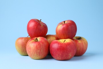 Ripe red apples on light blue background, closeup