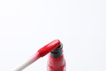 Beautiful lip gloss with applicator on white background, closeup. Space for text