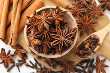 Mulled wine spices. Anise stars in bowl, cinnamon sticks and cloves on table, flat lay