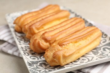 Fresh tasty eclairs on light table, closeup