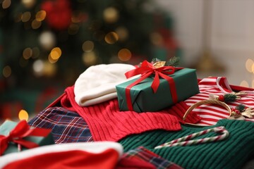 Christmas vacation. Suitcase with clothes, gift box and candy canes indoors, closeup