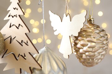 Obraz premium Beautiful Christmas decor hanging on string against blurred lights, closeup