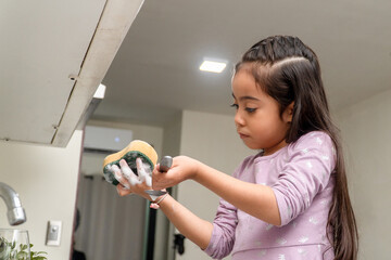 Little girl helping with household chores washing dishes