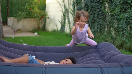Little boy and girl having fun playing together on an air mattress