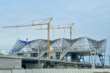 Rail Baltic station construction with cranes and steel roof structure in Riga, Latvia