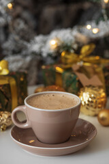 Cup of Hot Drink with Christmas Gifts and Ornaments in Cozy Holiday Setting against Christmas Tree and Lights
