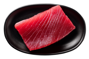deep red raw tuna fillet placed on smooth black oval plate with subtle texture and refined culinary style