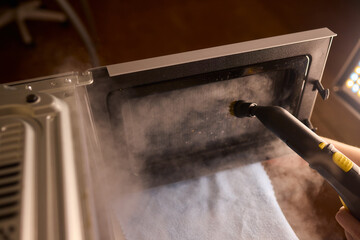 Cleaning microwave safely, Handheld steamer removes grime from microwave cavity efficiently, Ecofriendly steam cleaning method focuses on hygiene and appliance preservation