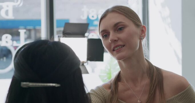 Close-up of a caucasian girl as a makeup artist applies makeup to a client.