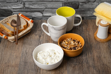 Delicious breakfast spread with bread, cottage cheese, and granola on a rustic wooden table