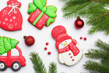 Tasty gingerbread cookies and Christmas decor on white background, flat lay