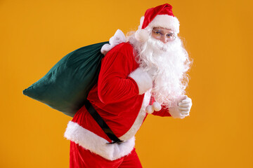 Santa Claus with bag on yellow background. Merry Christmas and Happy New Year