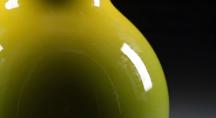 Vibrant yellowgreen glossy ceramic object, showcasing its smooth, reflective surface and elegant curve on a dark, minimalist background