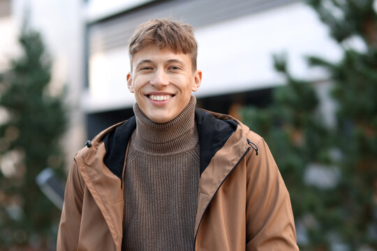 Portrait of smiling man in jacket on city street