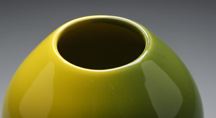 Closeup view of a vibrant green ceramic vase with a smooth, glossy finish and a modern, minimalist design, showcasing its elegant curve and narrow opening