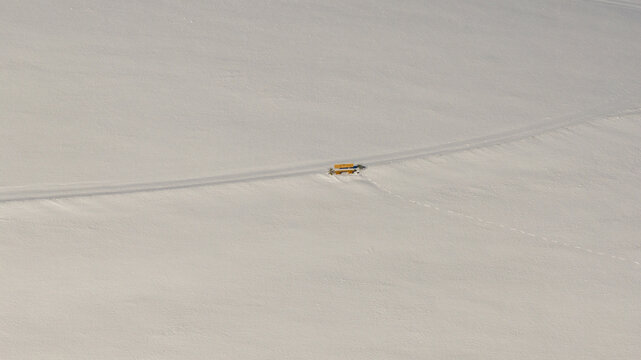 Winter scenery, drone aerial view, with single bench in deep snow nature