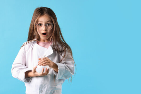 Emotional little girl in laboratory coat and glasses with flask on light blue background, space for text. Child and science - Powered by Adobe