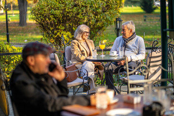 Senior couple enjoying drinks and conversation at an outdoor cafe