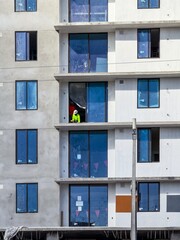 construction worker working on balcony without railing of building under construction