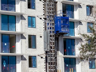 View of high rise building under construction with external elevator.