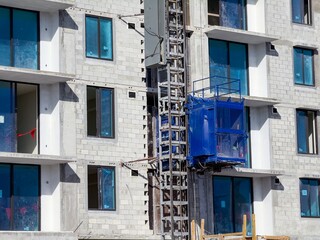 View of high rise building under construction with external elevator.