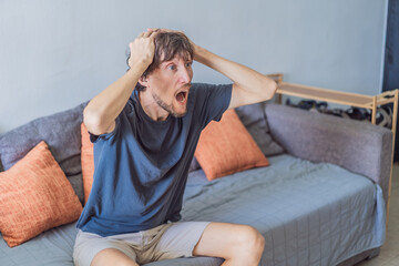 A man watching a football match on television at home, fully focused and relaxed in a cozy living room. Leisure time, sports entertainment, weekend relaxation and modern digital lifestyle concept
