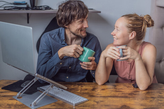 A man and his wife working from home together in their shared home office, focused on laptops in a bright modern workspace. Remote work, teamwork, productivity and contemporary work-life balance