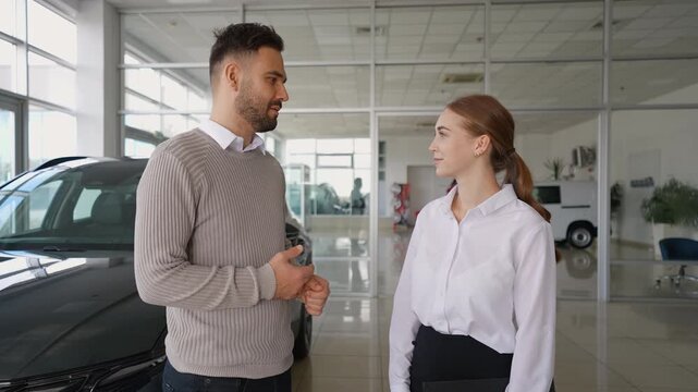 Car saleswoman handing keys and shaking hands with customer - Powered by Adobe