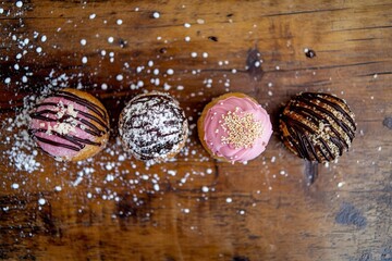 Assorted donuts with sprinkles on rustic wooden table