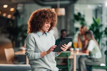 Diverse woman working on digital tablet in office