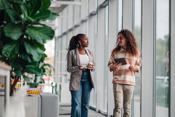 Coworkers walking and talking in modern office