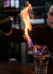 Bartender making a fire flame cocktail in a elegant night club party unique experience. . High quality photo
