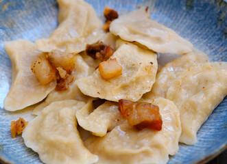 The hands of a senior home cook hold a plate with a national Slovak dish - Bryndzove Pirohy. High quality photo