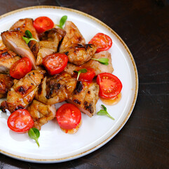 Healthy vegetable salad with spinach, grilled chicken, tomatoes, cucumber and red onion. Black table, top view. High quality photo