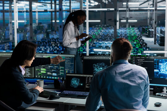 Software developers in data center installing upgraded server racks systems helped by AI technology. Server farm employees upgrading enterprise networks hardware using artificial intelligence