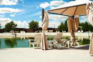Recreation complex with sun loungers and a covered tent with a pond in the middle