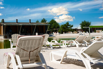 White deck chairs at a recreation center with a freshwater lake