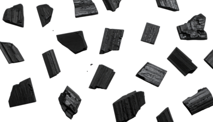 Black background with dispersed, irregular charcoal pieces, creating a texture with shadows and light