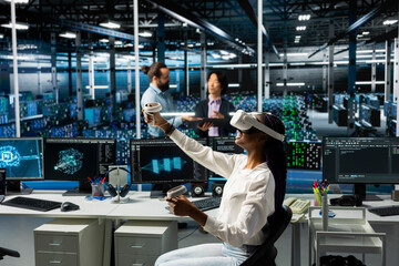Admin in data center using AI virtual reality to troubleshoot rigs connectivity issues. IT professional using VR headset in server hub, auditing systems for vulnerabilities using neural networks