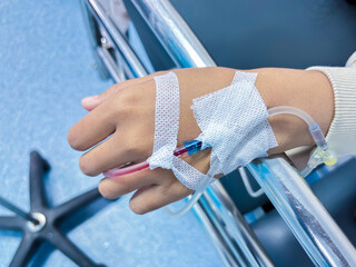Close up of child's hand with IV drip during hospitalization offering a poignant reminder of care