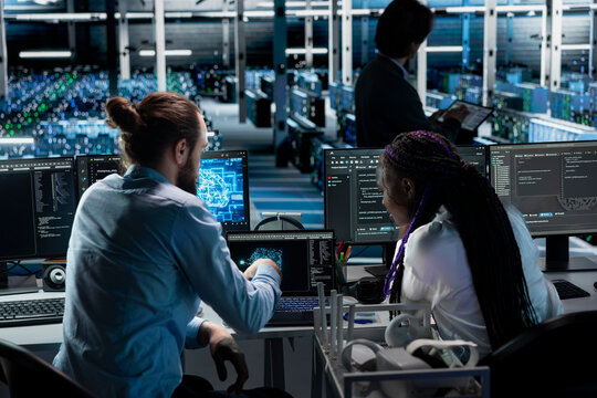 Teamworking server farm colleagues deploying AI tools to automate repetitive workflows. Team of data center engineers managing datasets used in artificial intelligence training, streamlining tasks - Powered by Adobe