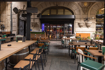 Shaded outdoor café terrace surrounded by greenery and trees