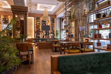 Contemporary restaurant design with wooden décor, bookshelves, and cozy velvet furniture