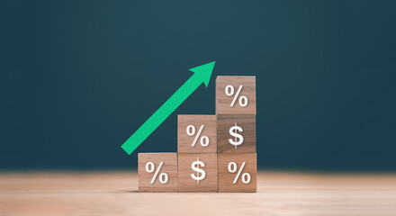 Financial growth concept. Wooden blocks showing dollar and percentage symbols and stacked upward with a rising green arrow. Profit, investment return, interest rate and economic increase.