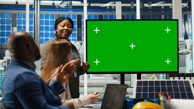 Solar panels plant manager uses isolated screen monitor to present manufacturing strategies to investors. Photovoltaics factory executive uses mockup display to show data to shareholders, camera B