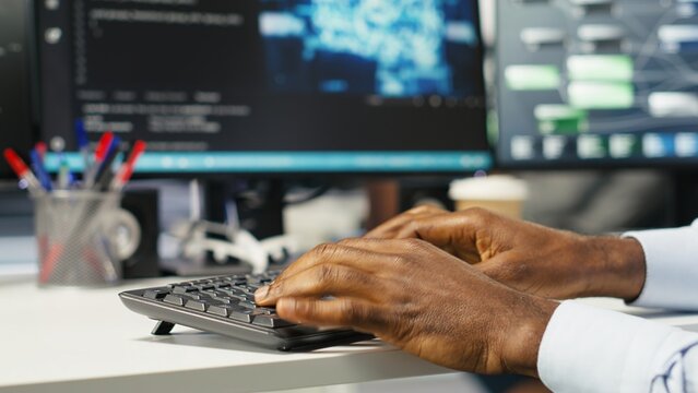 Data center computer scientist at desk using AI deep learning algorithms to analyze datasets. Server room IT specialist typing on PC keyboard, using artificial intelligence neural networks, camera B